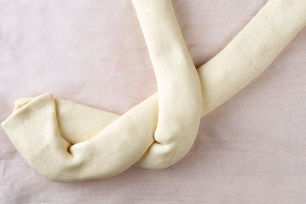 A megtöltött tésztát óvatosan koszorúvá tekerjük.