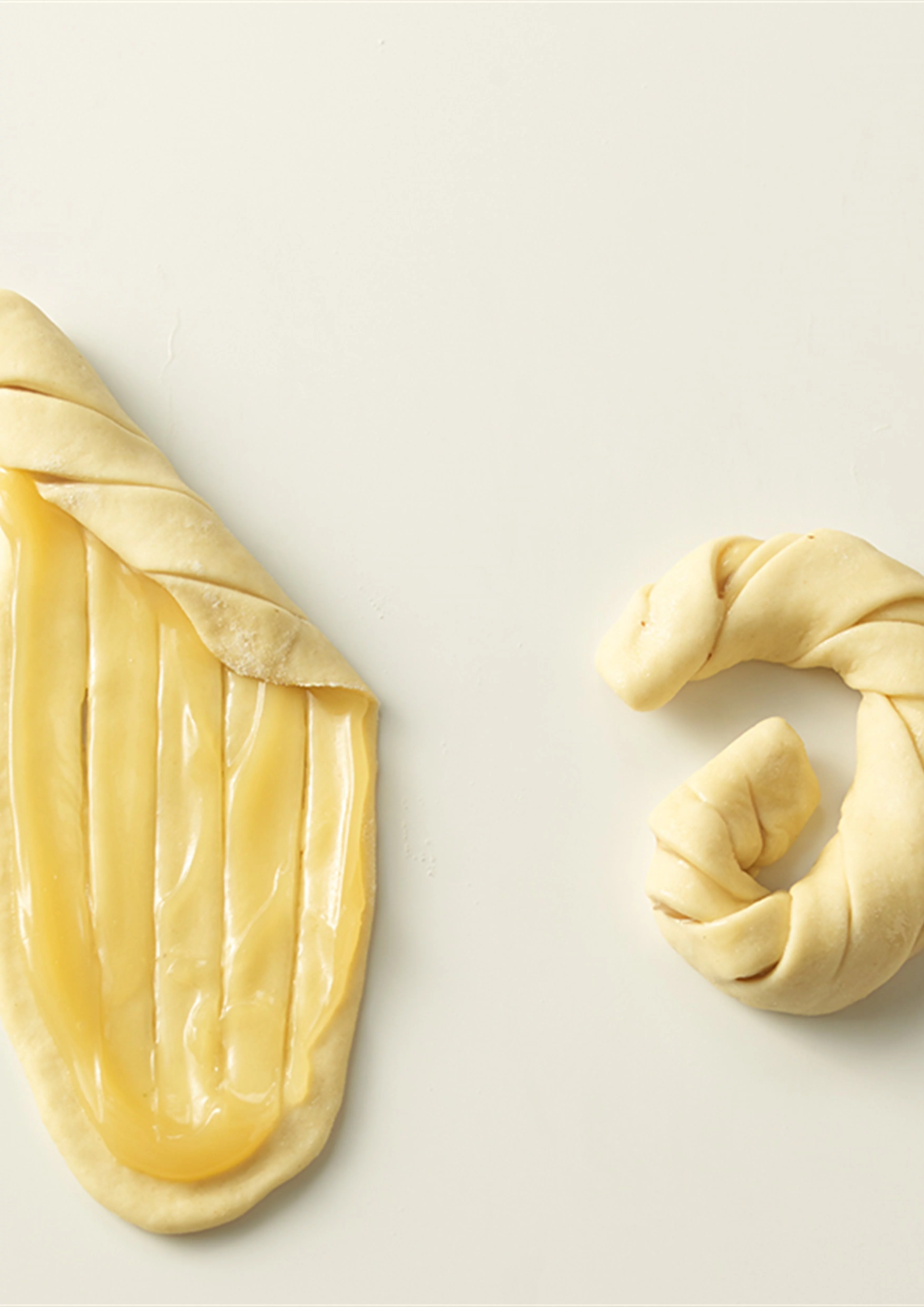 A Citromos húsvéti koszorúk tésztáját nyújtás után kenjük be a töltelékkel, majd feltekerjük.